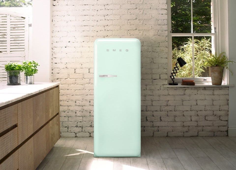Smeg Fab Pastellgrün an einer Ziegelwand